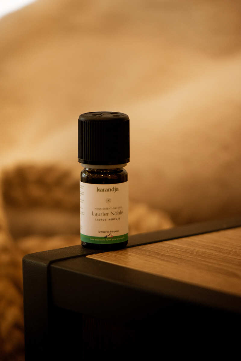 flacon d'huile essentielle de laurier noble bio posé sur une table