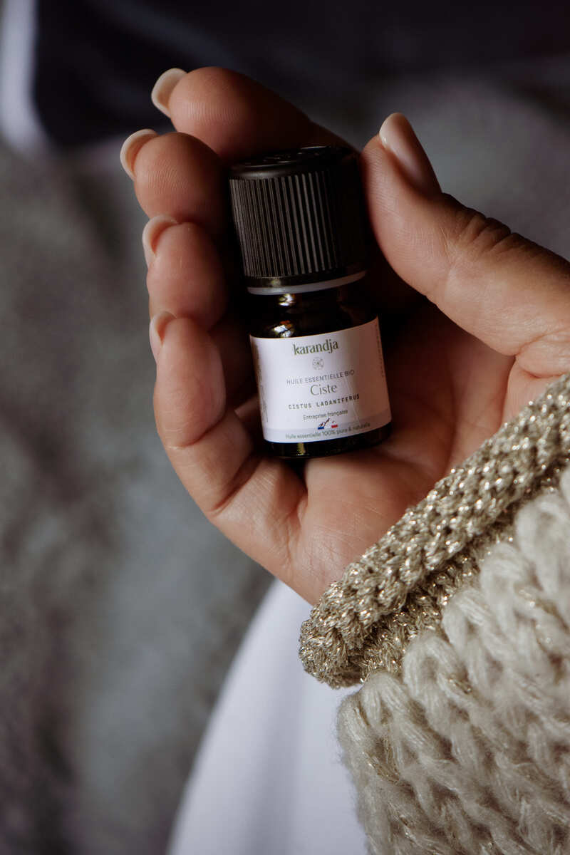 flacon d'huile essentielle de Ciste dans la main d'une personne